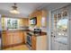 Kitchen featuring wood cabinets, granite countertops, a stainless steel oven, and a view to the porch at 1320 Golfview St, Orlando, FL 32804