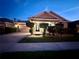 Charming single-story home with manicured front yard, brick driveway, and welcoming front porch under twilight at 13226 Zori Ln, Windermere, FL 34786