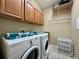 Functional laundry room featuring a washer, dryer, storage cabinets, and shelving for organizing essentials at 13226 Zori Ln, Windermere, FL 34786