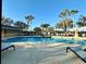 Community pool surrounded by palm trees and lounge chairs at 13226 Zori Ln, Windermere, FL 34786