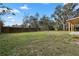 Large grassy backyard with a wooden fence and mature trees at 137 Stevens Ave, Chuluota, FL 32766