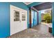 Bright blue covered back porch with wood decking, privacy walls, and outdoor seating at 13838 Walcott Ave, Orlando, FL 32827