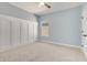 Blue bedroom with wainscoting features carpeting, a ceiling fan, and a window at 13838 Walcott Ave, Orlando, FL 32827