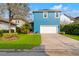 Bright blue two-story home with lush landscaping and a paved driveway at 13838 Walcott Ave, Orlando, FL 32827