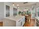 Kitchen island featuring white cabinets, quartz countertops, stainless steel appliances, and view to dining area at 13838 Walcott Ave, Orlando, FL 32827