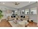 Comfortable living room with neutral sofas, plush rug, decorative pillows, and natural light from multiple windows at 13838 Walcott Ave, Orlando, FL 32827