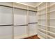 Spacious walk-in closet with custom shelving, hanging rods, and hardwood floors offers an abundance of storage at 13838 Walcott Ave, Orlando, FL 32827