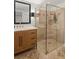 Modern bathroom featuring a glass shower, travertine tile, and a wood vanity with marble countertop at 1410 Osceola Ct, Orlando, FL 32806