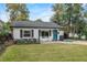 Inviting single-Gathering home with a well-kept lawn, blue front door, and quaint rocking chairs on the porch at 1410 Osceola Ct, Orlando, FL 32806