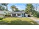 Well-manicured front lawn and landscaping with an inviting white exterior and a striking blue front door at 1410 Osceola Ct, Orlando, FL 32806