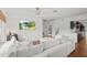 Bright living room featuring white sofa, barrel accent table, ceiling fan and decorative brick floors at 1410 Osceola Ct, Orlando, FL 32806