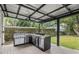 Outdoor kitchen with stainless steel grill, countertop space, and ceiling fan at 1410 Osceola Ct, Orlando, FL 32806