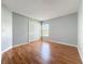 Empty bedroom showing closet with white doors, a window, and wood flooring at 15323 Torpoint Rd, Winter Garden, FL 34787