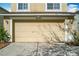 Close-up of a two-car garage door featuring house numbers on the top right side of the garage at 15323 Torpoint Rd, Winter Garden, FL 34787