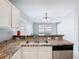 Close-up of kitchen with stainless steel appliances, ample countertop space, and view to the dining area at 15323 Torpoint Rd, Winter Garden, FL 34787