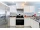 Modern kitchen with stainless steel appliances, white cabinetry, and ample counter space for cooking at 15323 Torpoint Rd, Winter Garden, FL 34787