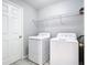 Bright laundry room with washer, dryer, white wire rack, and a neutral paint at 15323 Torpoint Rd, Winter Garden, FL 34787