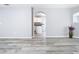 Bright living room featuring modern gray floors, light gray walls, and an arched doorway to the kitchen at 15323 Torpoint Rd, Winter Garden, FL 34787