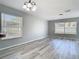 Bright living room with modern gray floors, overhead lighting, and large windows showcasing the backyard at 15323 Torpoint Rd, Winter Garden, FL 34787