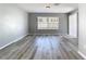 Inviting living room with modern gray floors, large windows, and neutral walls, offering a serene atmosphere at 15323 Torpoint Rd, Winter Garden, FL 34787