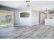 Open concept living room with modern gray floors, view of backyard, and arched doorway to the kitchen at 15323 Torpoint Rd, Winter Garden, FL 34787