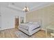 Spacious bedroom with tray ceiling, neutral colors, and natural light with an adjoining bathroom at 15772 Murcott Harvest Loop, Winter Garden, FL 34787