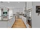 Modern kitchen with stainless steel appliances, hardwood floors, and sleek white cabinets at 15772 Murcott Harvest Loop, Winter Garden, FL 34787