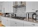 Close up of the kitchen stove, featuring a sleek backsplash and stainless steel range hood at 15772 Murcott Harvest Loop, Winter Garden, FL 34787