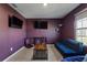 Cozy living room featuring a blue sofa, wood coffee table, and wall-mounted TVs, perfect for relaxing and entertaining at 1629 Hill Park Dr, Deltona, FL 32725