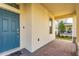 Inviting front porch with brick flooring and a stylish blue front door at 17846 Adrift Rd, Winter Garden, FL 34787