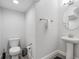 Neat half-bathroom featuring a pedestal sink, grey tile floors, and modern fixtures at 17846 Adrift Rd, Winter Garden, FL 34787