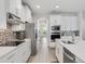 Modern kitchen featuring stainless steel appliances, white cabinets, and backsplash at 17846 Adrift Rd, Winter Garden, FL 34787