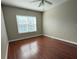 Bright bedroom features a ceiling fan, hardwood floors, and a large window for natural light at 202 E South St # 5037, Orlando, FL 32801