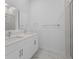 Modern bathroom featuring double sinks, white cabinets, marble floors, and a glass shower door at 205 Famagusta Dr, Davenport, FL 33896