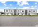 Row of modern townhomes featuring gray stone accents and neat front lawns at 205 Famagusta Dr, Davenport, FL 33896