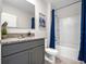 Well-lit bathroom features a shower-tub combo, granite countertop, framed mirror and sleek gray cabinetry at 2105 Red Rock Rd, New Smyrna Beach, FL 32168