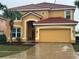 Inviting two-story home with a red tile roof, attached two-car garage, and well-maintained landscaping at 232 Rubino Dr, Davenport, FL 33837