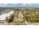 Wide aerial view of the townhome community, with the lake, surrounding trees, and nearby shopping center at 2344 Aloha Bay Ct, Ocoee, FL 34761