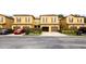 Exterior view of townhouses with garages and neutral colored facade and well maintained landscaping at 2344 Aloha Bay Ct, Ocoee, FL 34761