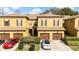 Townhome complex with well-maintained landscaping, individual garages, and inviting facade at 2344 Aloha Bay Ct, Ocoee, FL 34761