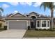 Inviting single-Gathering home featuring a two-car garage, gray facade and landscaped front yard at 2502 Cypress Trace Cir, Orlando, FL 32825