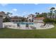 Community pool with tiled roof pavilion and lounge chairs is surrounded by manicured landscaping at 2502 Cypress Trace Cir, Orlando, FL 32825