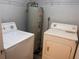 A compact laundry room with a washer, dryer, and hot water heater at 3028 Parkway Blvd # 305, Kissimmee, FL 34747