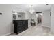 Elegant hallway with dresser, mirror and chandelier, leading to kitchen at 331 Bay St, Auburndale, FL 33823