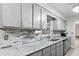 Modern kitchen featuring gray cabinets, marble countertops, and stainless steel appliances at 331 Bay St, Auburndale, FL 33823