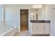 Bathroom featuring a soaking tub, granite vanity, and a walk-in closet through an open doorway at 3431 Islewood Ct, Ocoee, FL 34761