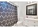 Bathroom with a modern sink and vanity with a black framed mirror and geometric shower curtain at 34500 Tree Frog Ln, Eustis, FL 32736