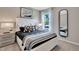 Bright bedroom with a decorative black and white theme, large window, bedside table, and a full-length mirror at 3476 Sandalwood Isle Way, Ocoee, FL 34761