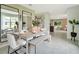 Bright dining room with a modern table, bench, and a view into an open living area at 3476 Sandalwood Isle Way, Ocoee, FL 34761