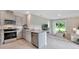 Modern kitchen flowing into the living room with stainless steel appliances and ample counter space at 3476 Sandalwood Isle Way, Ocoee, FL 34761